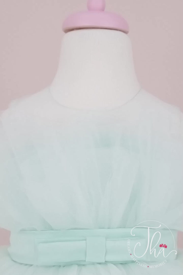 360° view of a tiffany sleeveless prom dress that has knee length fluffy multi layered skirt, belt, and tiffany illusion collar