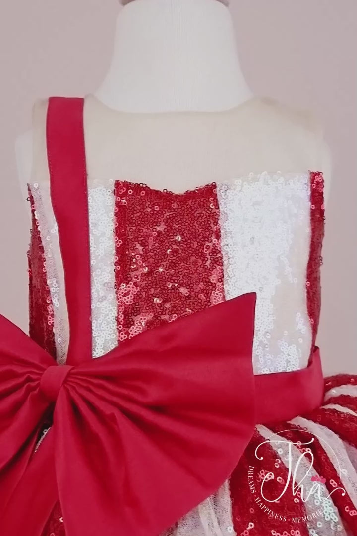360° view of a white and red Christmas dress. The dress has a lined red and white sequin top, a knee length red skirt, red ribbon. The skirt is made of layers of red tulle