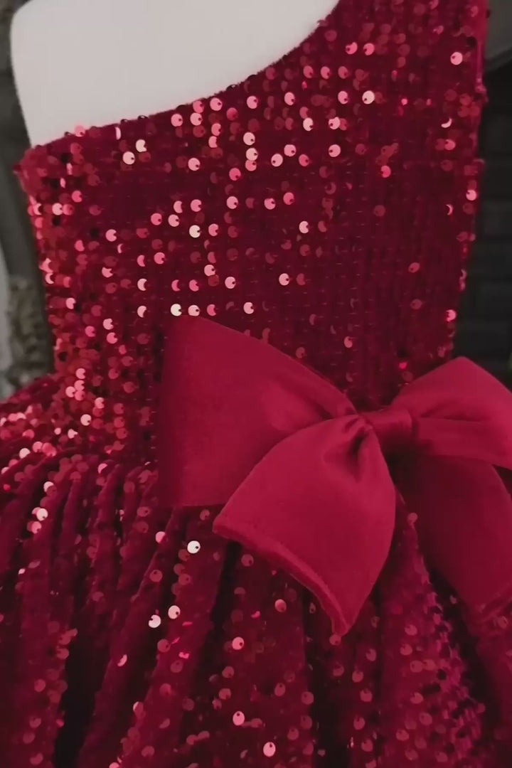 360° view of a red hologram sequin one shoulder open Christmas dress that has velvet ribbon and knee length skirt