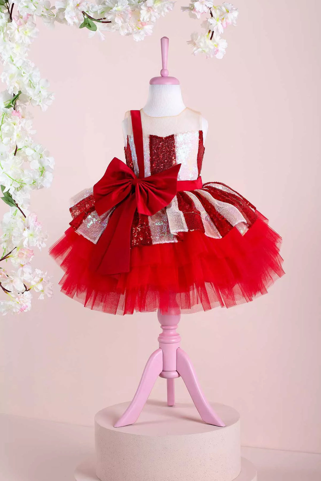 A white and red Christmas dress. The dress has a lined red and white sequin top, a knee length red skirt, red ribbon. The skirt is made of layers of red tulle