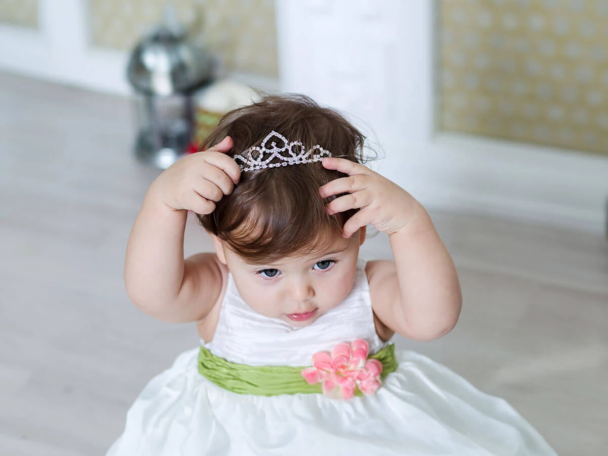 A baby girl wearing cute hair crown.