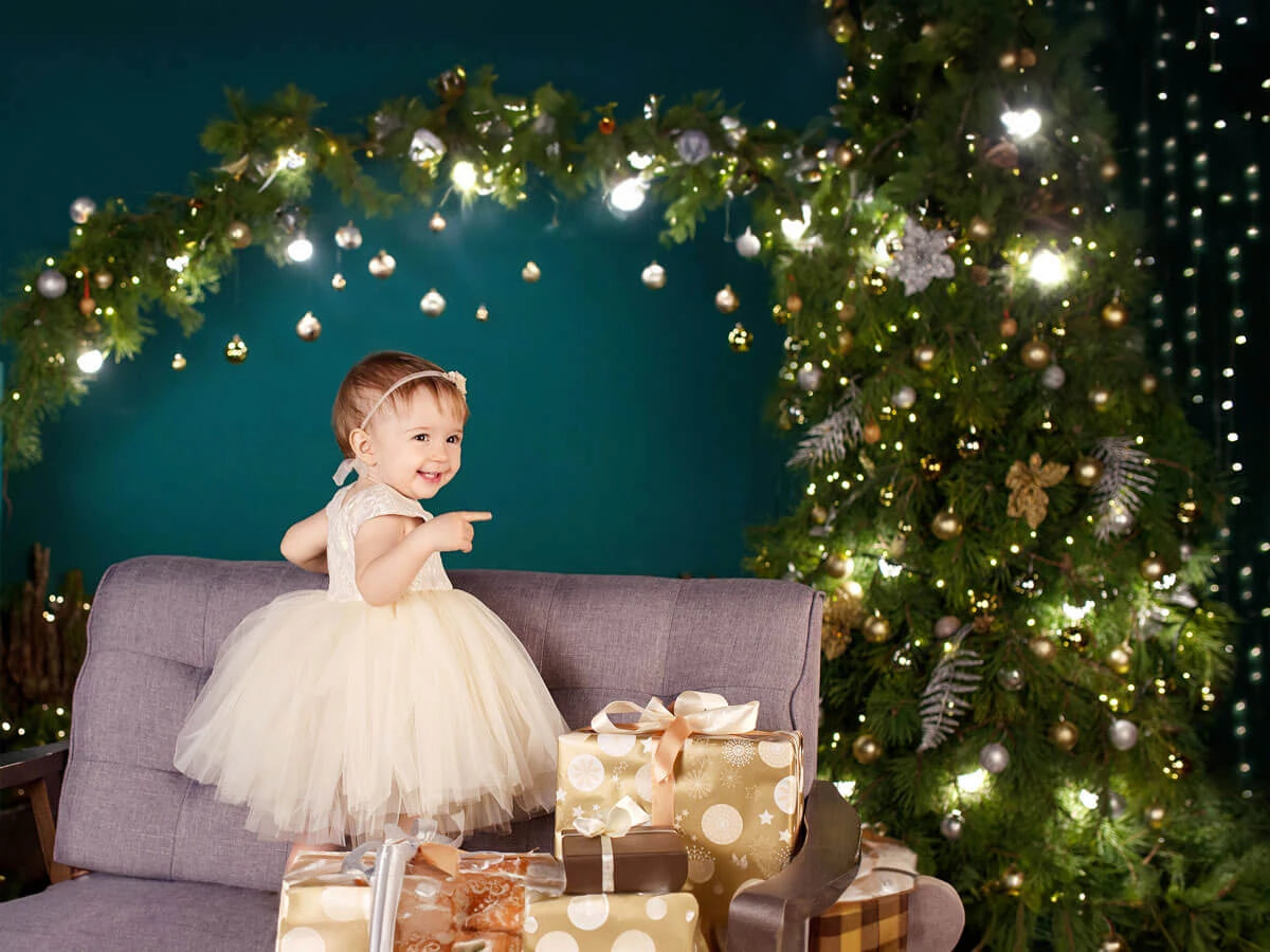 A baby girl wearing fancy Christmas dress.