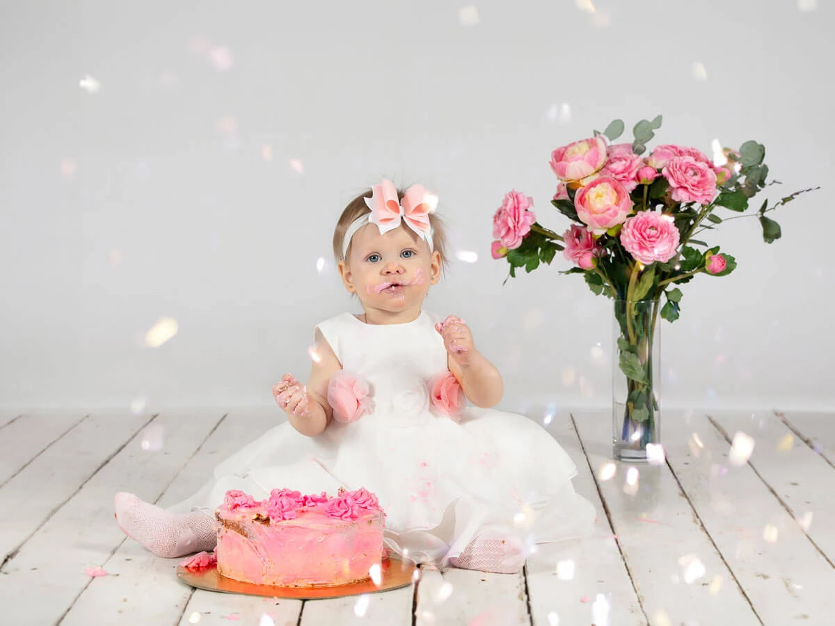 A little baby girl wearing cute princess birthday dress.