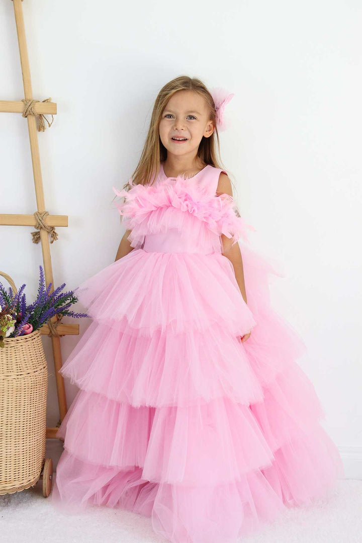 A sleeveless pink princess wedding dress. The dress has floor length skirt, satin top, and feathers on chest