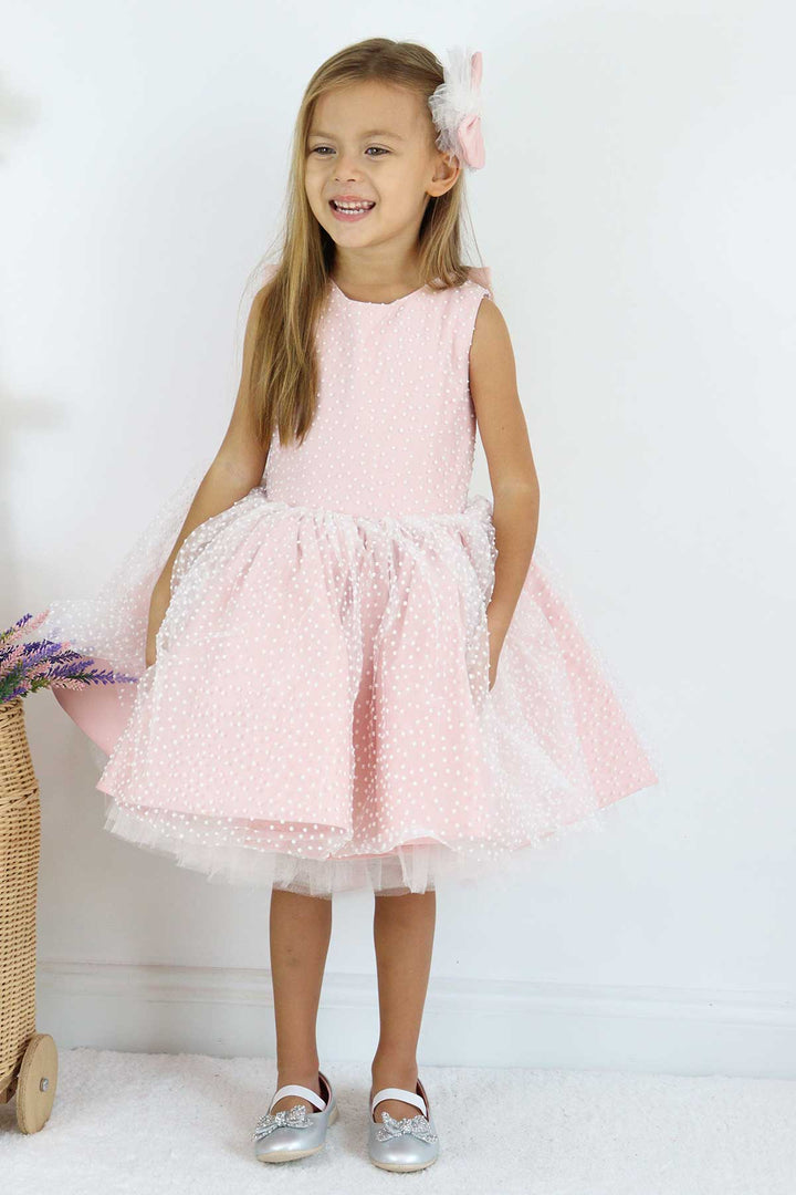 A pink sleeveless birthday dress that has snow foam, knee length fluffy skirt, and satin top