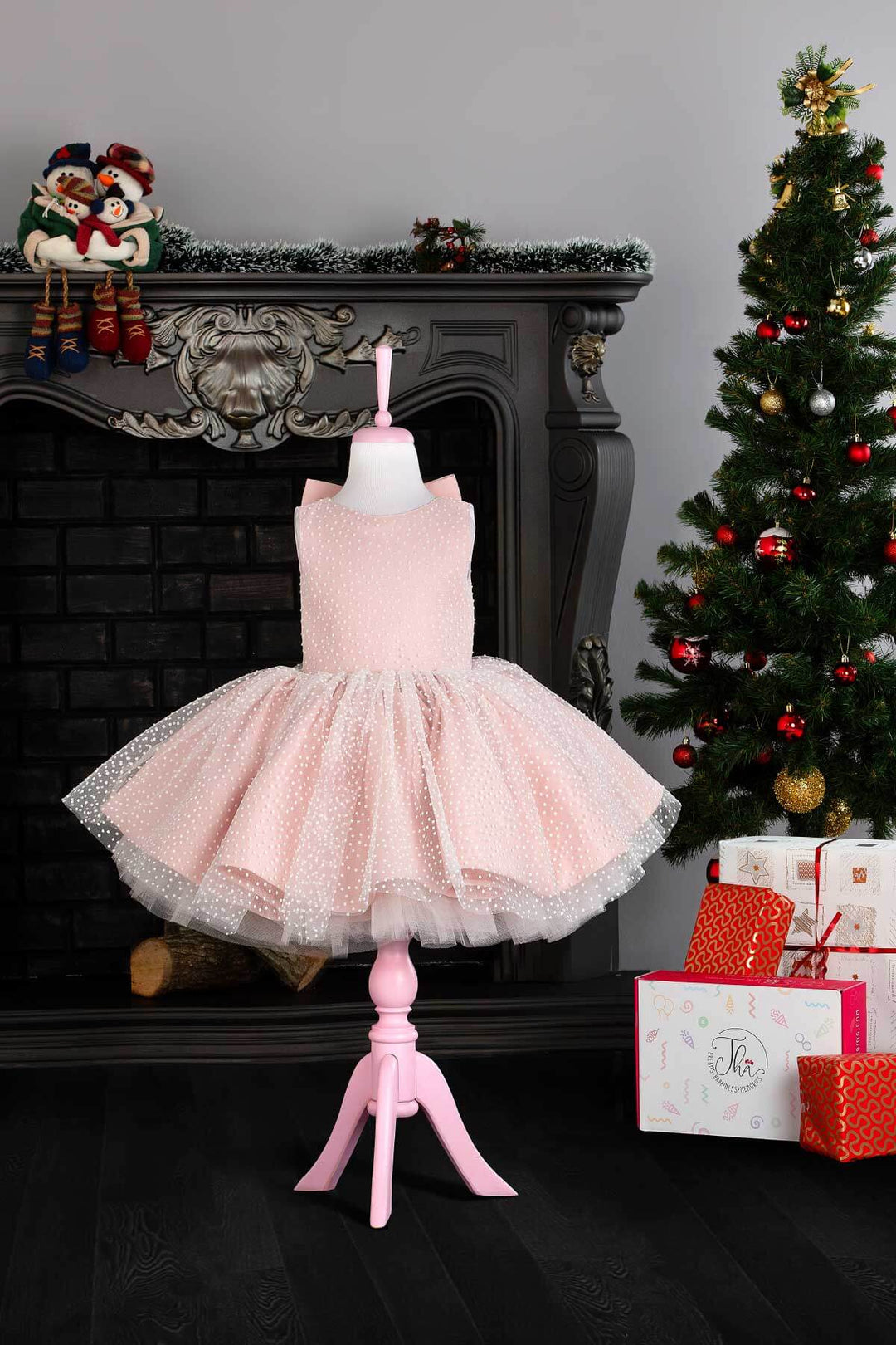 A pink sleeveless birthday dress that has snow foam, knee length fluffy skirt, and satin top