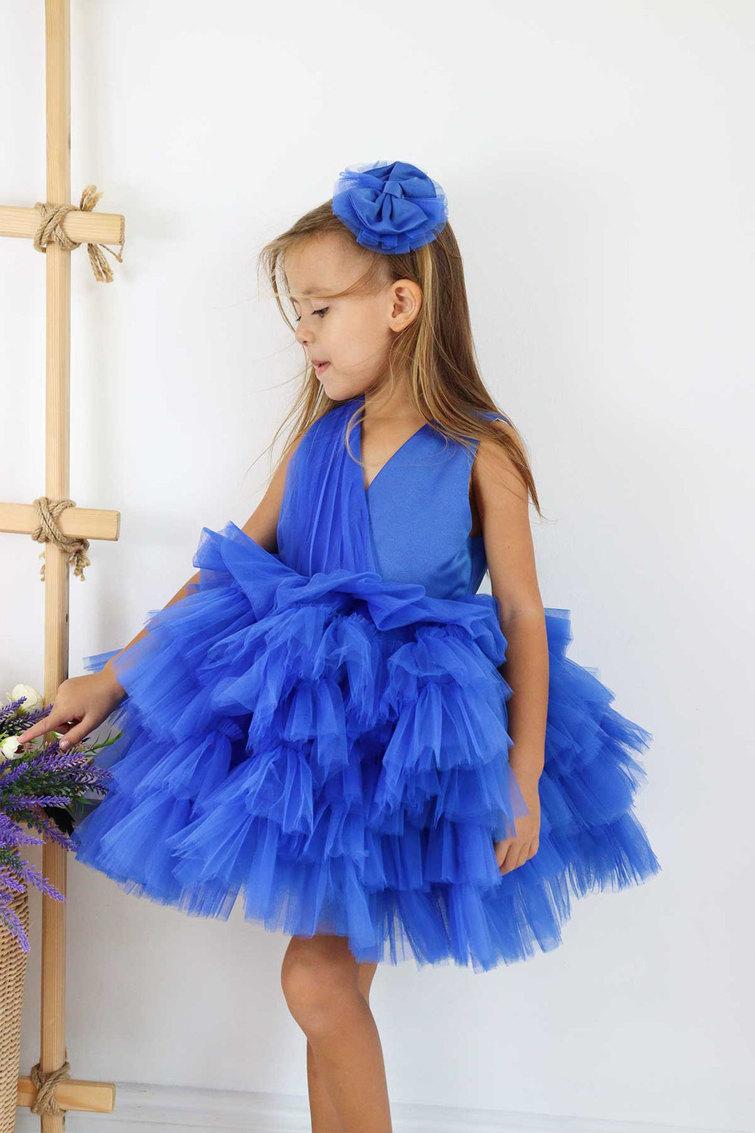 A sax blue sleeveless frozen themed dress that has knee length multi layered puffy skirt and V-neck