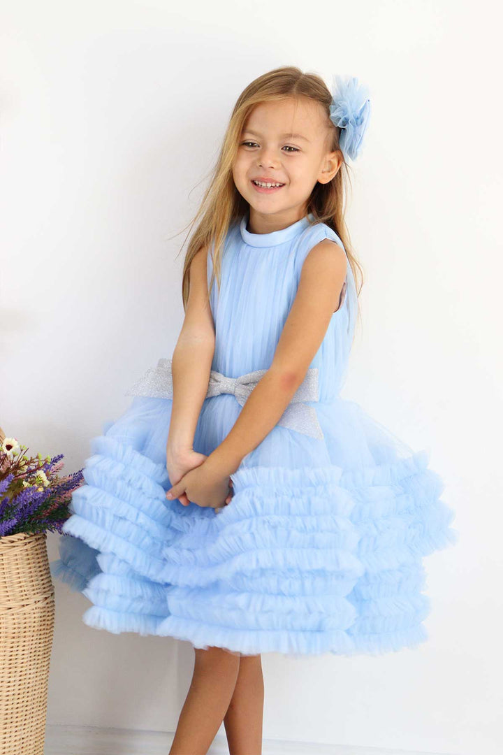 A blue sleeveless elegant dress that has judge collar, tulle top, shirred tulle knee length skirt, and shiny tulle bow