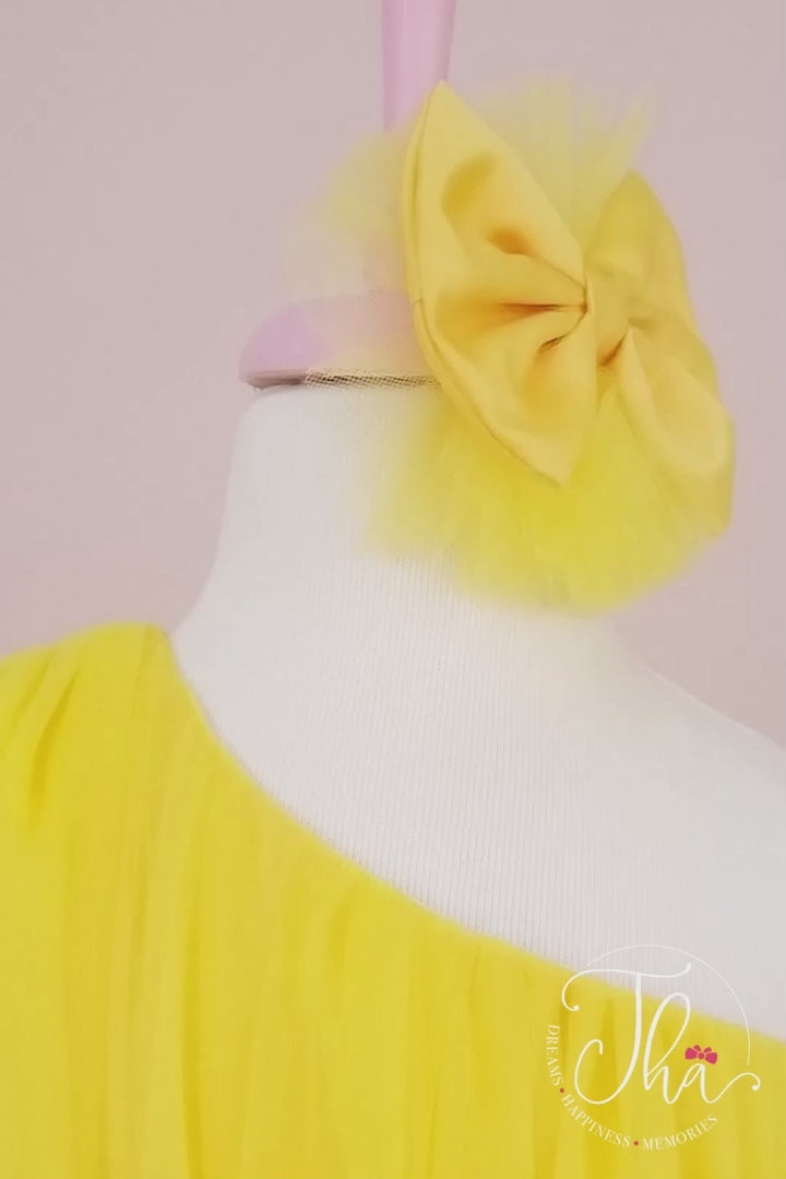 360° view of a yellow one shoulder open Sun themed sleeveless dress that has knee length shirred skirt