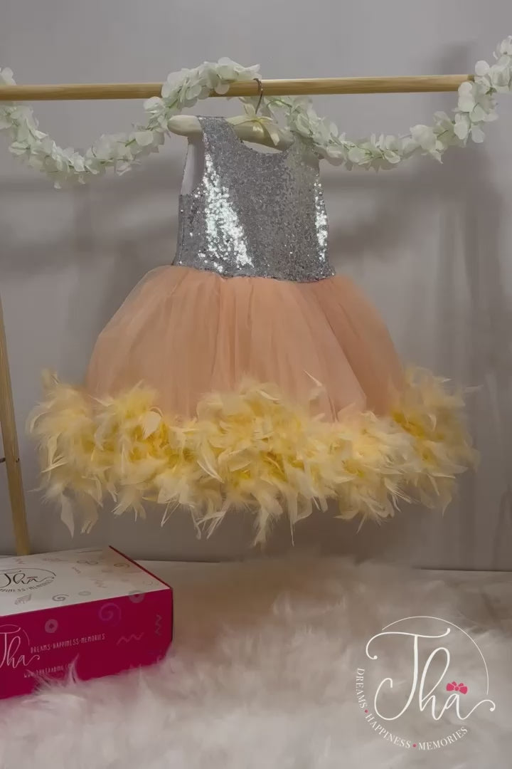 360° view of a silver and powder first birthday party dress with silver sequin top and knee length powder puffy skirt with feathers on the bottom, and a bow