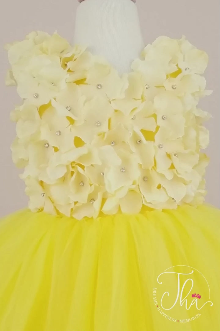 360° view of a yellow first birthday dress. The dress has 3D yellow flowers and attached rhinestones on top and fluffy skirt