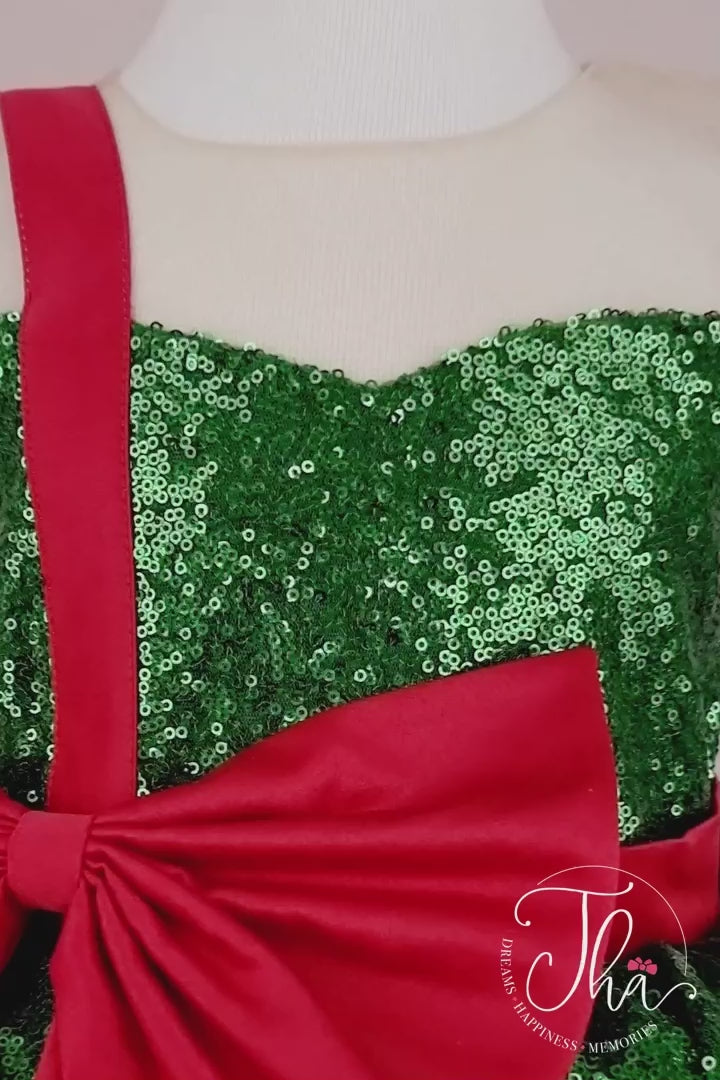 360° view of a light green and red Christmas dress. The dress has a green sequin top, a knee length red skirt, red ribbon. The skirt is made of layers of red tulle