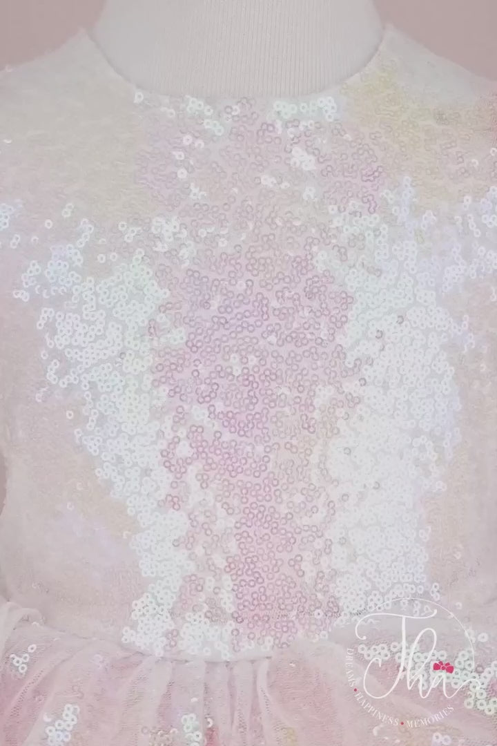 360° view of a light pink tutu princess dress which has cap sleeve, feathers on arms, sequin fabric top, bow, and layered skirt