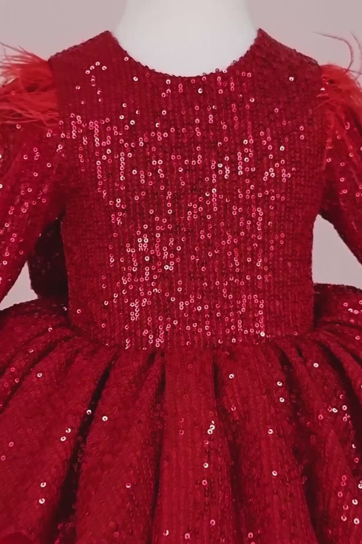 360° view of a red Christmas dress that has long sleeves, red sequin top and bow, feathers, V design, and knee length tulle layered skirt