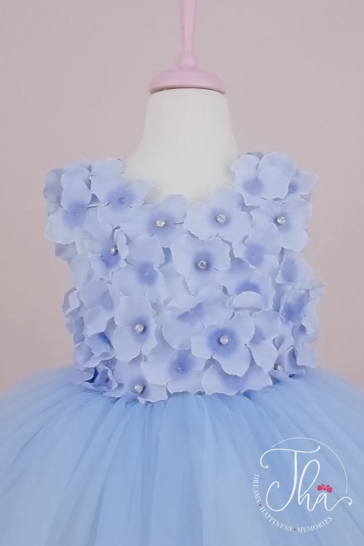 360° view of a baby blue first birthday dress which has 3D baby blue flowers and attached rhinestones on top and fluffy skirt
