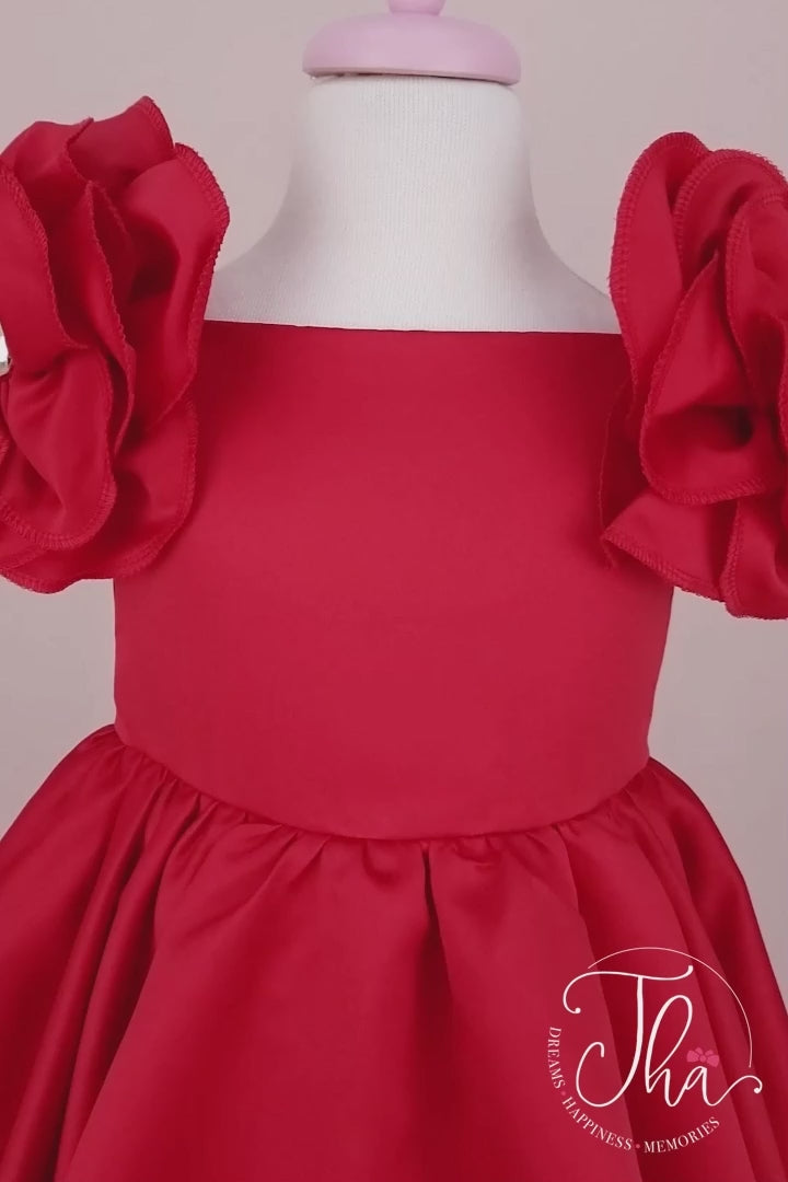 360° view of a red special occasion concept dress that has satin fabric, 3D flowers on shoulders, boat collar, and knee length skirt