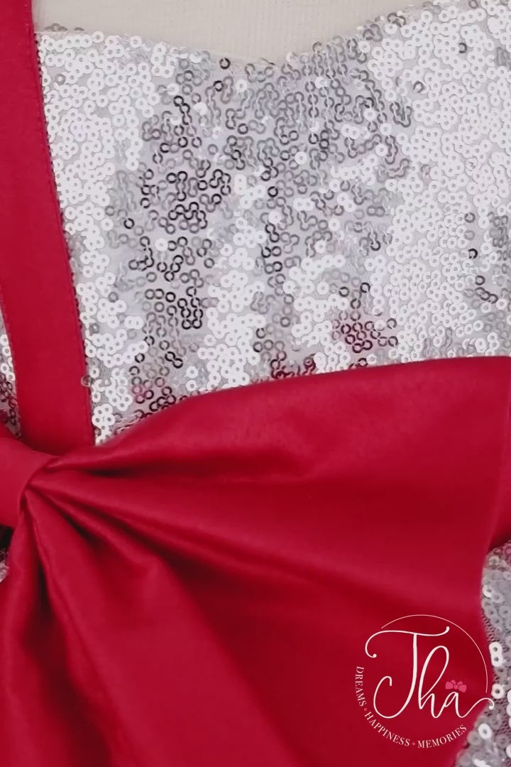360° view of a silver and red Christmas dress. The dress has a silver sequin top, a knee length red skirt, red ribbon. The skirt is made of layers of red tulle