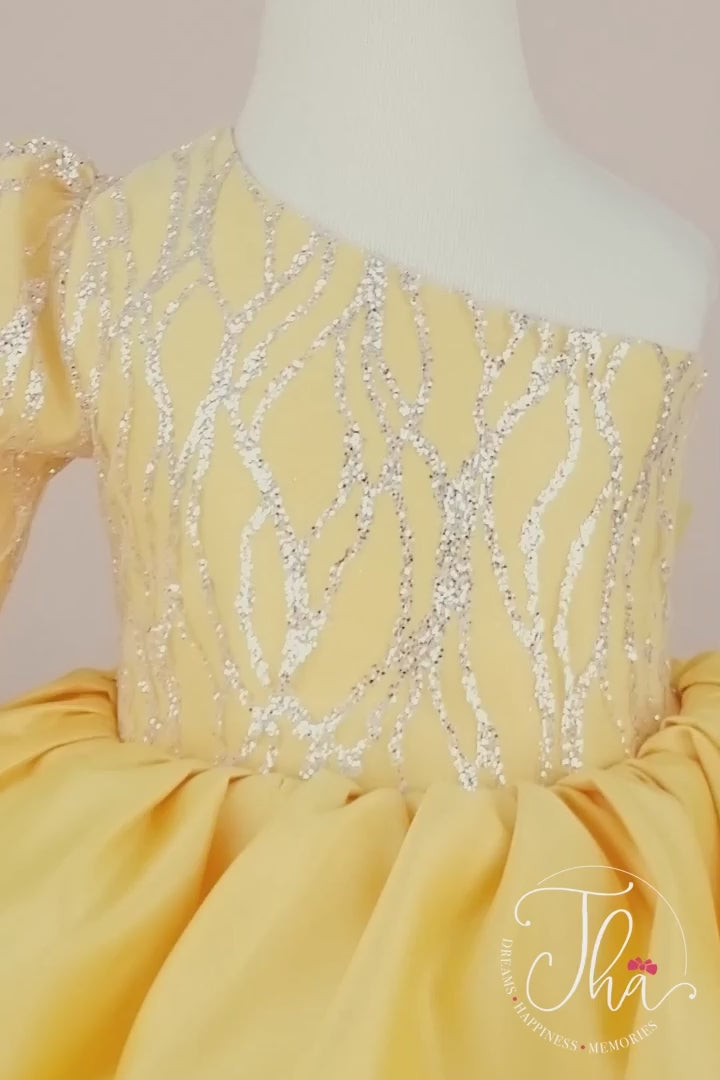360° view of a yellow one shoulder open dress. The dress has puffy skirt, watermark silver patterns, and bow