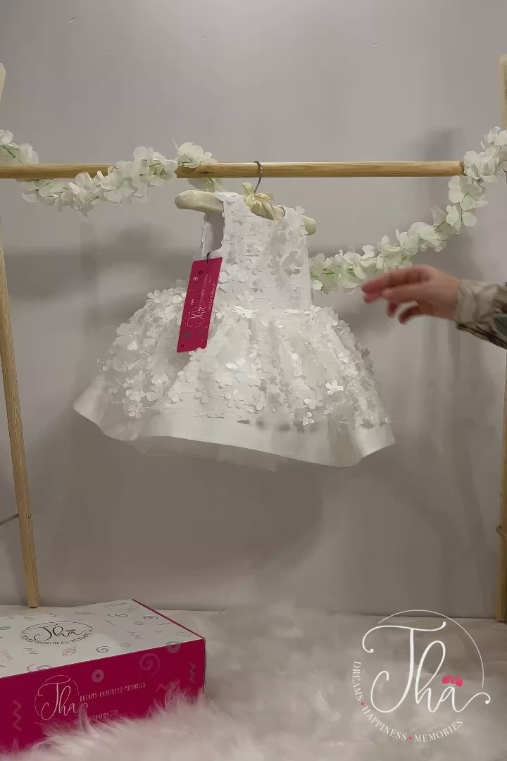 360° view of a white snow themed floral sleeveless dress that has 3D flowers and low skirt