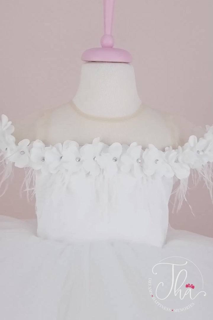 360° view of a white sleeveless bridesmaid dress that has 3D flowers with rhinestones, cap sleeve, feathers, illusion collar, satin top, and hi-low skirt