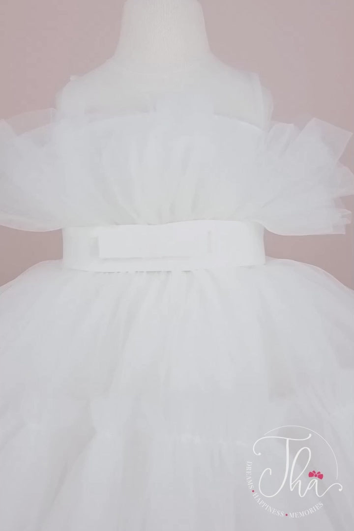 360° view of a white sleeveless princess dress that has knee length fluffy multi layered skirt, belt, and white illusion collar