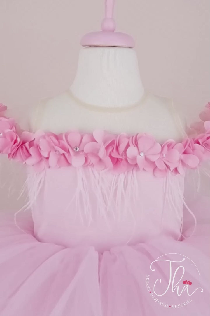 360° view of a pink sleeveless princess dress that has 3D flowers with rhinestones, cap sleeve, feathers, illusion collar, satin top, and hi-low skirt