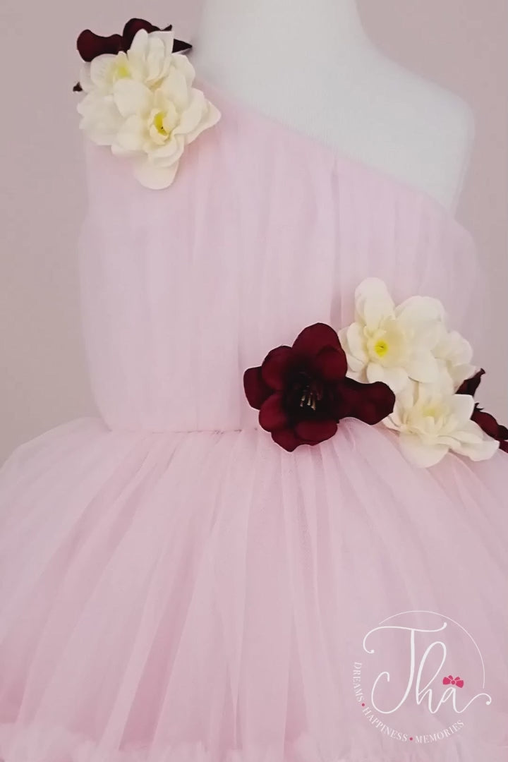 360° view of a pink one shoulder open sleeveless summer fairy dress that has knee length shirred skirt and 3D flowers.