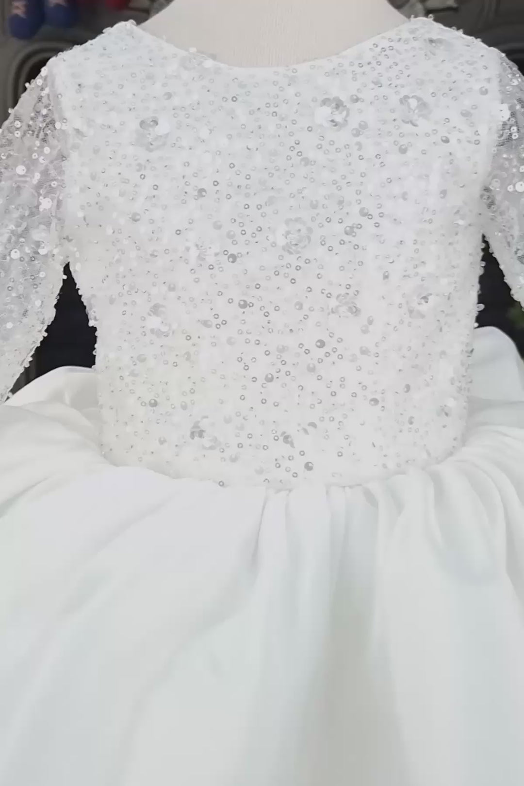 360° view of a white full sleeve bridesmaid dress that has white 3D sequins, bow, and knee length puffy skirt