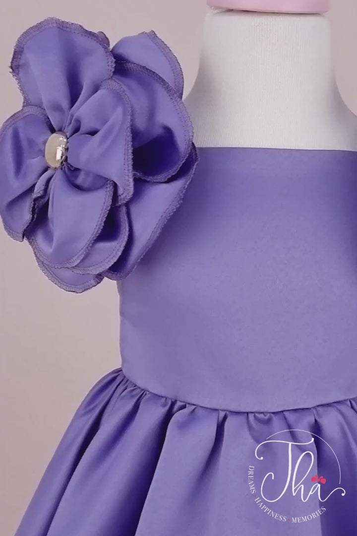 360° view of a purple special designer concept dress that has satin fabric, 3D flowers on shoulders, boat collar, and knee length skirt