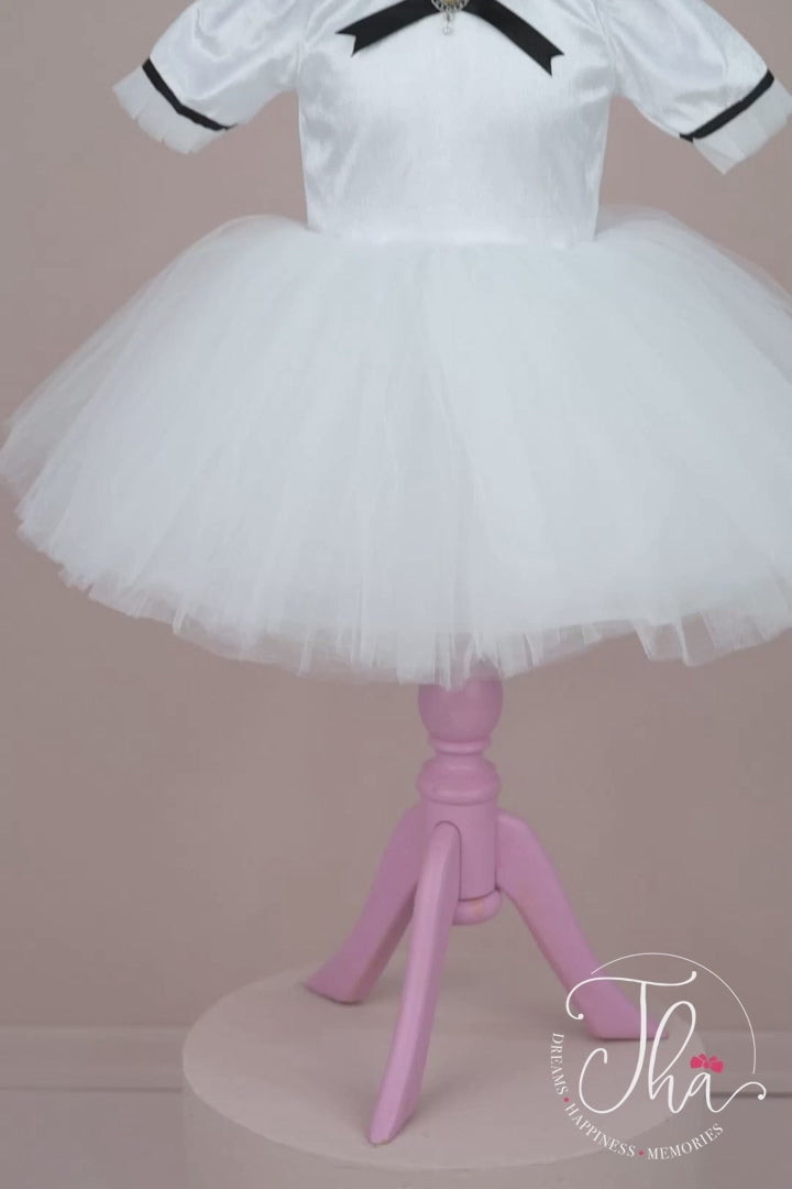 360° view of a white velvet dance dress that has knee length tulle skirt, judge collar, half sleeve, brooch on collar, white tulle ruffle and black ribbon on the neck and sleeve ends