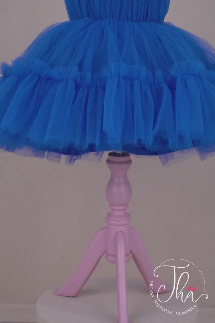 360° view of a sax blue Frozen themed one shoulder open sleeveless dress that has knee length shirred skirt