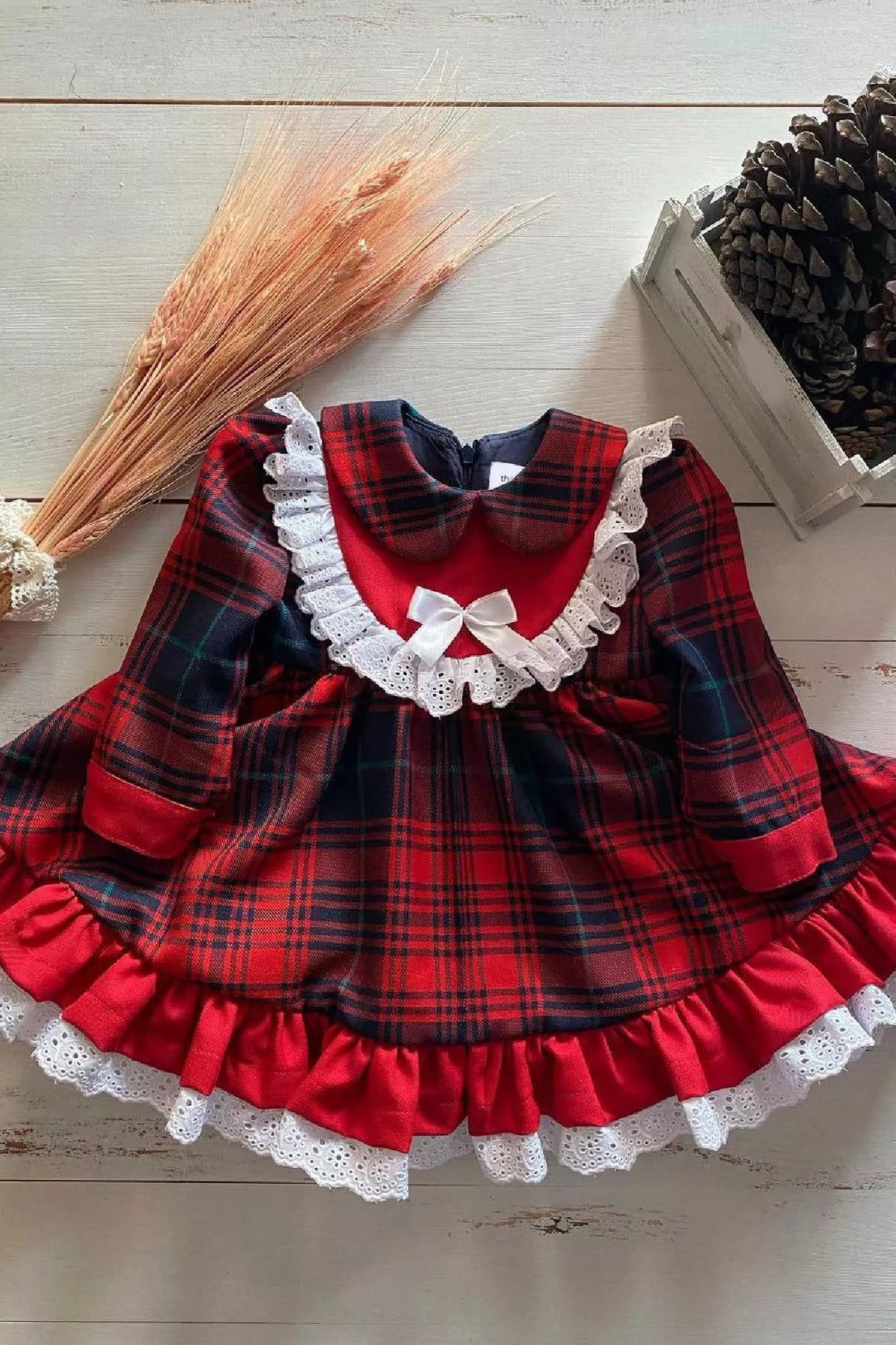 A red plaid scalloped vintage dress that has long sleeves, ribbon, scalloped ruffle on chest and hems, and knee length skirt