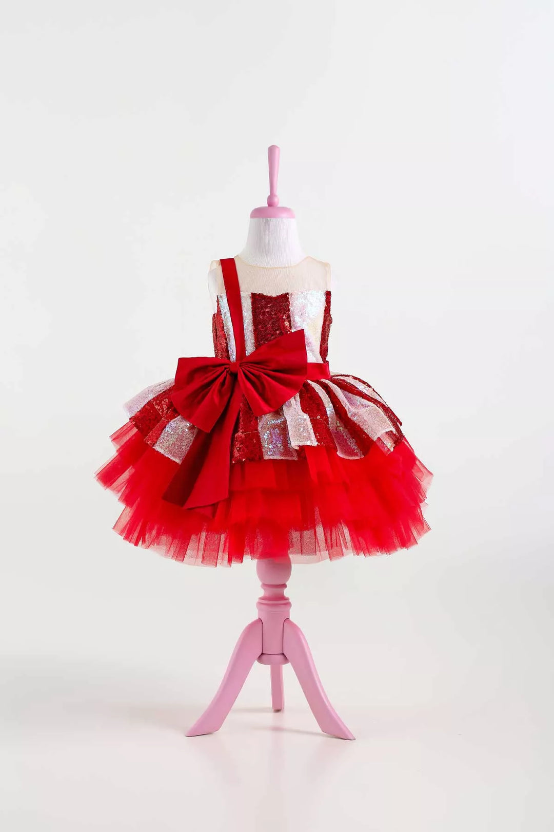 A white and red Christmas dress. The dress has a lined red and white sequin top, a knee length red skirt, red ribbon. The skirt is made of layers of red tulle