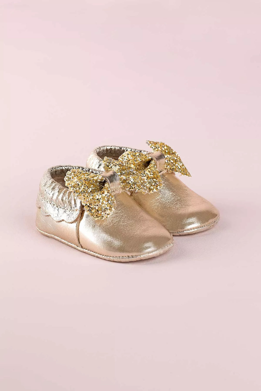 Yellow baby shoes that have glitter bow tie.