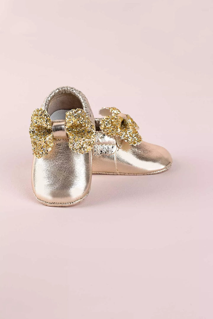 Yellow baby shoes that have glitter bow tie.