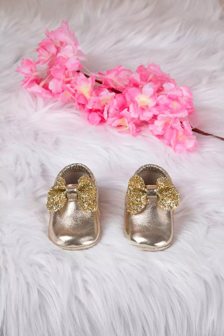 Yellow baby shoes that have glitter bow tie.