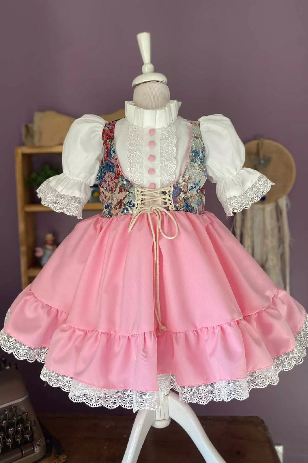 A pink Easter vintage dress that has self-corset, judge collar, half sleeves, scarf, ribbon, shirring and scallop embroidery, and cotton shirt