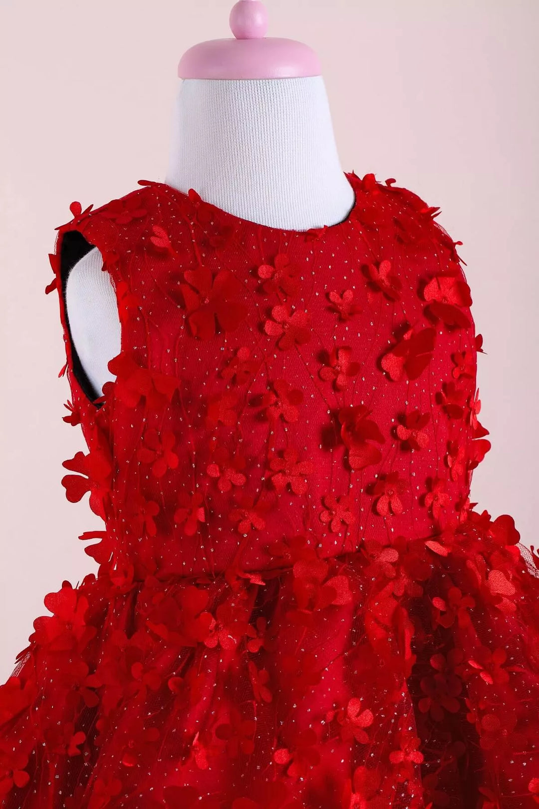 Close up view of a red floral sleeveless Little Red Riding Hood dress that has 3D flowers and red puffy skirt