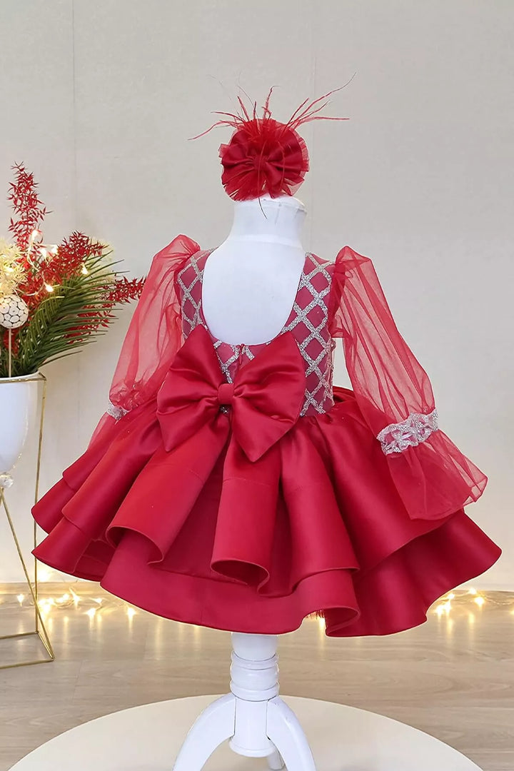 Back view of a red full sleeve diamond glitter pattern Christmas dress that has red skirt, satin top, tulle sleeve design, and bow
