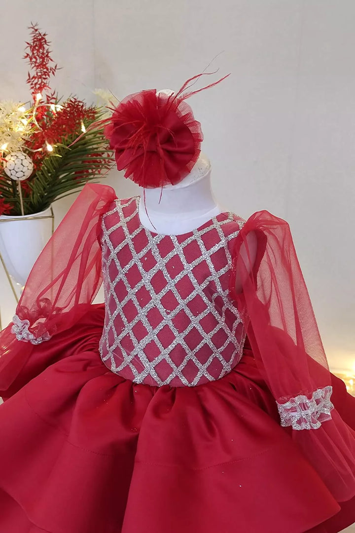 Close up view of a red full sleeve diamond glitter pattern Christmas dress that has red skirt, satin top, and tulle sleeve design