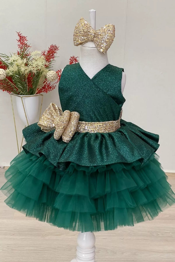 An elegant green sleeveless lurex fabric fairy dress that has gold sequin belt and bow and multi layered skirt