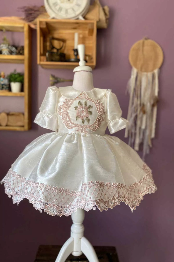 A white vintage dress that has silk slub with embroidery and French lace, baby collar, shirred half sleeves, French lace on hems, and knee length skirt