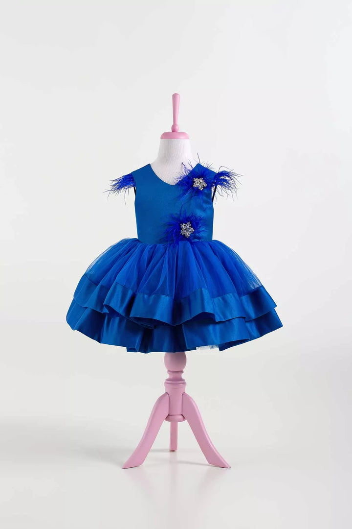 A sax blue sleeveless stage dress that has stars with crystal stones on top, feathers, satin top, and tulle and satin knee length skirt