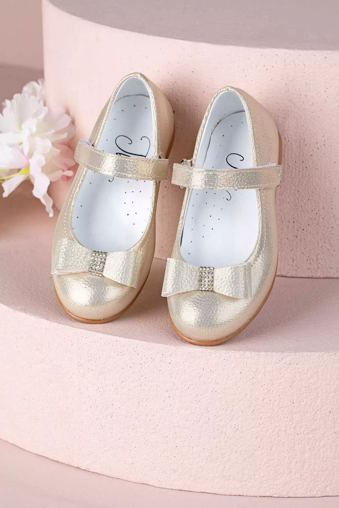 Gold toddler shoes that have crystal stone ornaments and bow tie