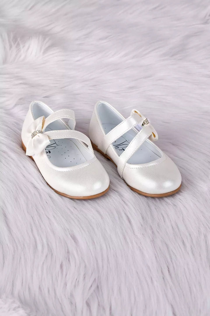 Ivory toddler shoes that have crystal stone ornaments and bow tie
