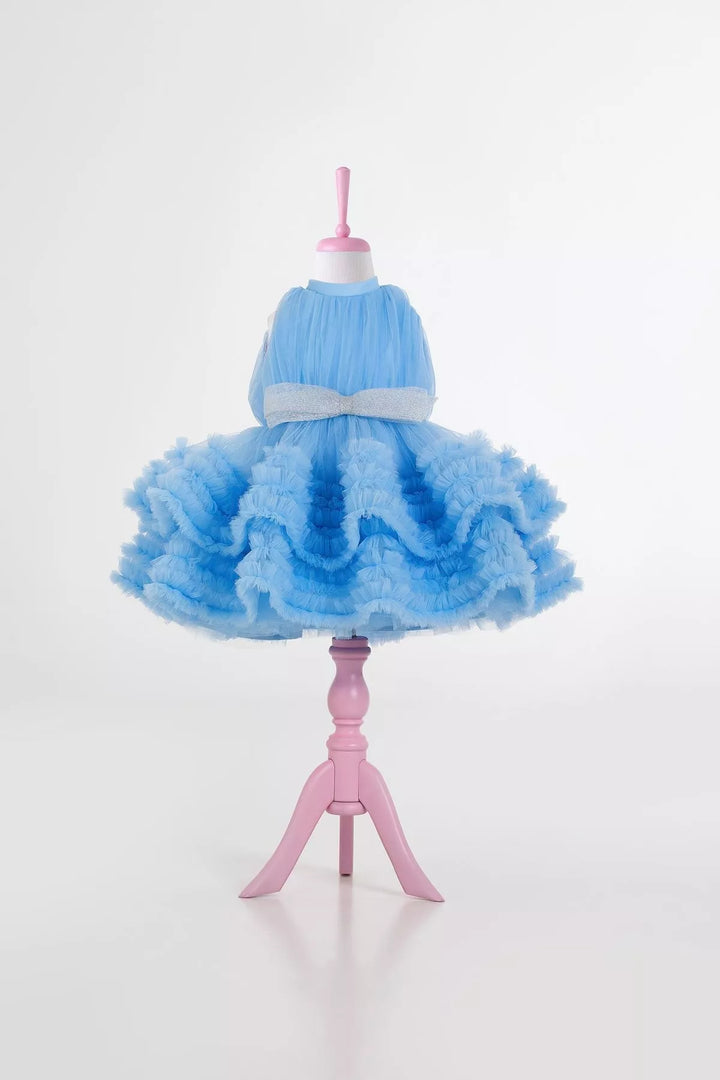 A blue sleeveless elegant dress that has judge collar, tulle top, shirred tulle knee length skirt, and shiny tulle bow