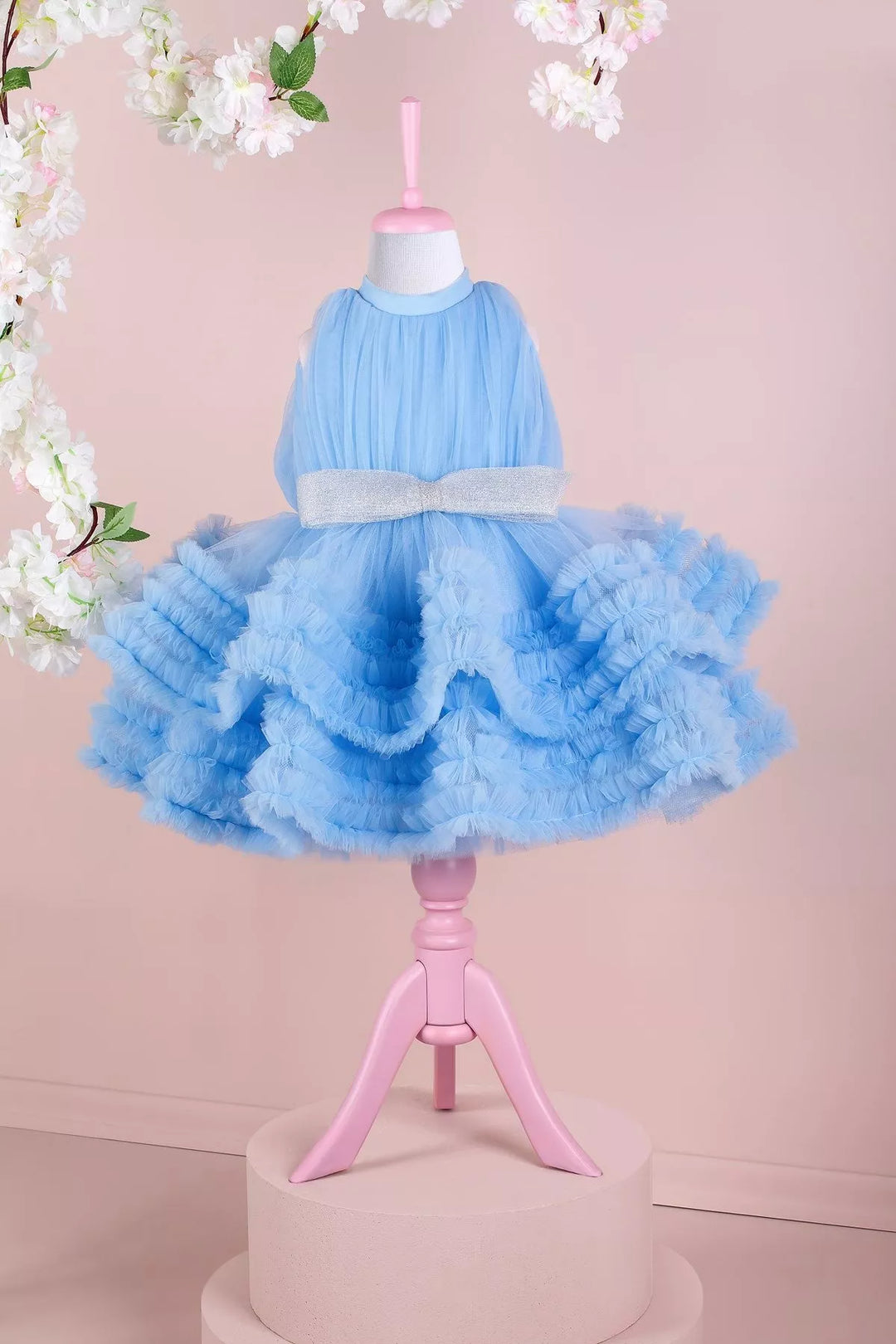 A blue sleeveless elegant dress that has judge collar, tulle top, shirred tulle knee length skirt, and shiny tulle bow