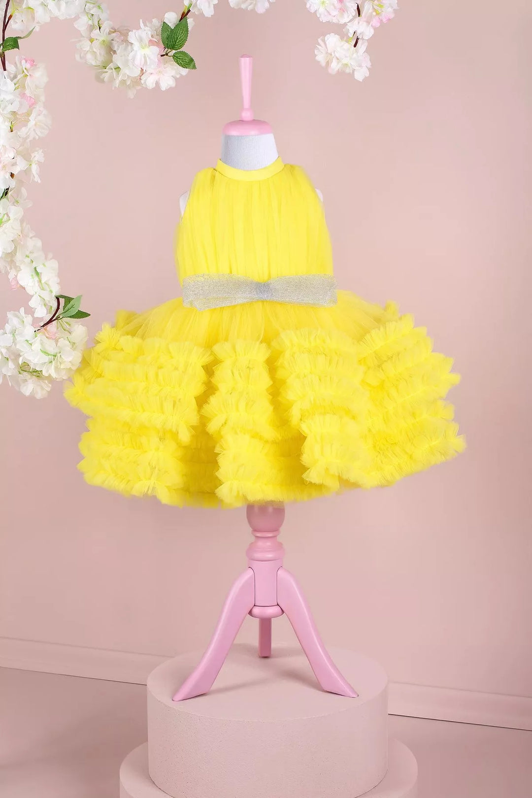 A yellow sleeveless birthday dress that has judge collar, tulle top, shirred tulle knee length skirt, and shiny tulle bow